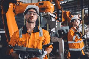 ingeniero equipo Servicio robot soldadura trabajando en automatización fábrica. personas trabajador en la seguridad traje trabajo robótico brazo software programación o reemplazando parte en automatizado fabricación industria tecnología. foto