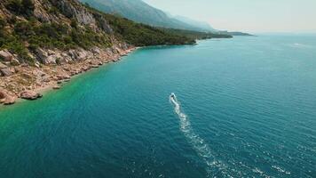 costero felicidad en Croacia. barco cremalleras mediante el zafiro mar aguas, escabroso acantilados en makarska riviera. video