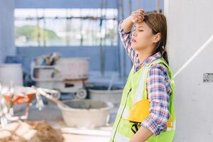 woman worker tired from work hard overwork fatigue be sick at construction site photo