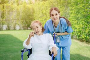 enfermero cuidado mayor mayor mujer a hogar Jubilación personas recuperación en silla de ruedas a al aire libre parque jardín. foto