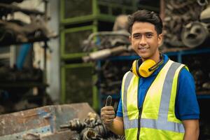 retrato asiático joven masculino ingeniero personal trabajador capataz trabajo en pesado industria contento sonriente foto
