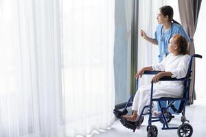 Nurse care elderly senior woman at home retirement people recovery on wheelchair. photo