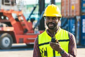 africano negro masculino trabajador capataz trabajo carga controlar cargando operador en envase Envío muelle yarda foto