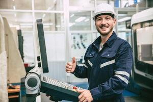 happy smile thumbs up engineer worker work with CNC Lathe Machine in modern metal factory photo