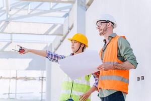 Construction engineer with architect team working check building construction progress at construction site photo