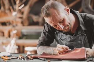 Leather maker artist handcraft working at own workshop small studio made by order masterwork piece photo