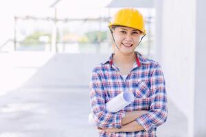 Engineer builder woman worker foreman. Portrait Asian girl architect home designer with floor plan. photo