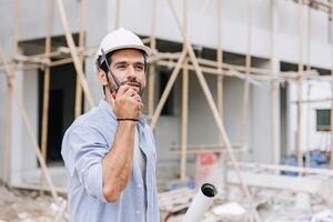 Hispanic latin indian builder work in construction site. Architect home project chief engineer with floor plan. photo