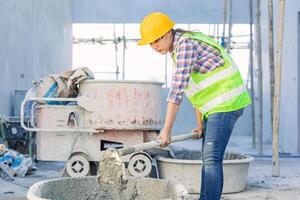 asiático mujer trabajador trabajo duro como un labor personal en construcción sitio trabajo mezcla hormigón cemento por mano foto