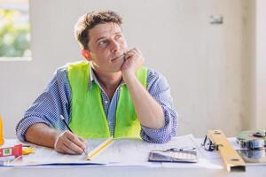 Construction engineer architect working at construction site with building floor plan looking out for thinking new idea project vision photo