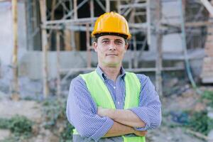 retrato ingeniero constructor. contento capataz confidente brazo cruzado proyecto trabajador arquitecto líder hombre foto