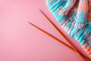 AI generated Knitting needles and unfinished colorful knitted sweater on pink background. Generative AI photo