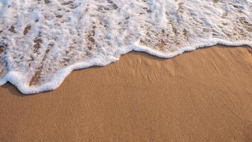 blanco espumoso antecedentes de olas estrellarse en un arenoso playa. foto