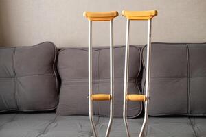 Close-up of metal crutches. Crutches for broken legs rest on the sofa photo