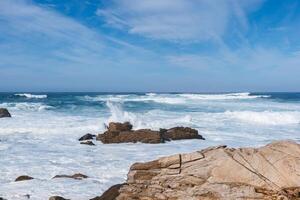 blanco olas golpear rocas en el Oceano apuntalar foto