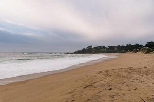 White waves hitting rocks on the ocean shore photo