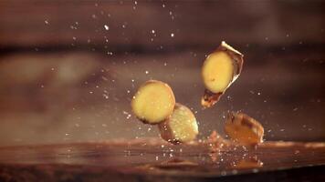 Pieces of fresh ginger fall on the table. Filmed on a high-speed camera at 1000 fps. High quality FullHD footage video