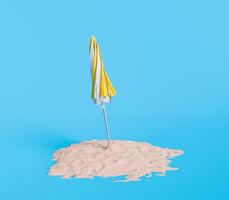 Closed Yellow and White Umbrella on Sand Pile Against Blue Background photo