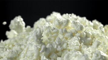 Fresh cottage cheese falling on black background. Filmed on a high-speed camera at 1000 fps. High quality FullHD footage video