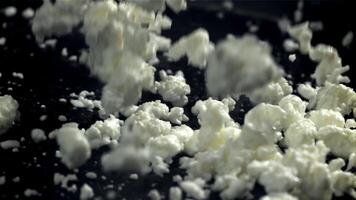 Fresh cottage cheese falling on black background. Filmed on a high-speed camera at 1000 fps. High quality FullHD footage video