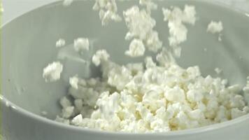 Fresh cottage cheese falls into the bowl. Filmed on a high-speed camera at 1000 fps. High quality FullHD footage video