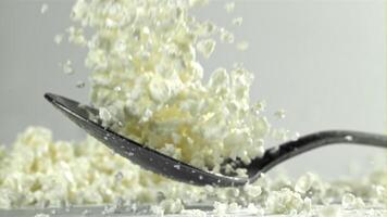 A spoonful of fresh cottage cheese falls on the table. Filmed on a high-speed camera at 1000 fps. High quality FullHD footage video