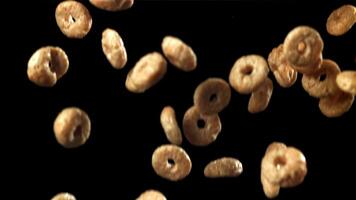 Corn flakes falling on black background. Filmed on a high-speed camera at 1000 fps. High quality FullHD footage video