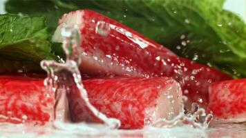 Drops of water fall on fresh crab sticks. Filmed on a high-speed camera at 1000 fps. High quality FullHD footage video