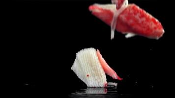 Fresh crab sticks falling on black background. Filmed on a high-speed camera at 1000 fps. High quality FullHD footage video