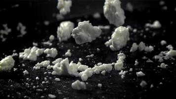 Fresh cottage cheese falling on black background. Filmed on a high-speed camera at 1000 fps. High quality FullHD footage video