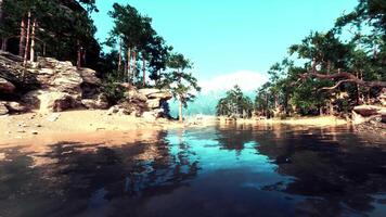 een lichaam van water omringd door bomen en rotsen video