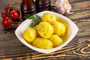 Boiled potato with oil and dill photo