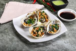 Open half oysters with green onion photo