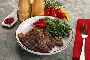 Grilled chuck roll steak with arugula photo