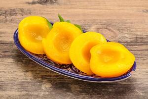 Sweet ripe canned peaches with mint photo