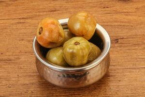 Pickled green tomato in the bowl photo