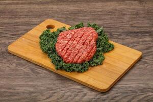 Raw beef burger cutlet for cooking photo