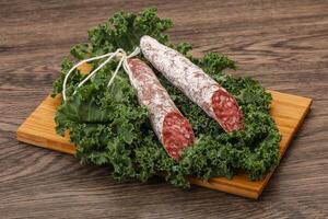 Spanish Fuet sausage with salad leaves photo