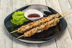 Minced pork skewer kebab with sauce photo