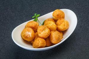 Sweet tasty profiteroles heap in the bowl photo