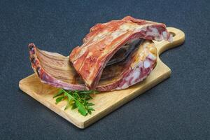 Smoked pork ribs over the wooden background photo