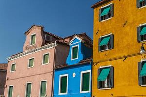 la fila de casas coloridas en la calle burano, italia. foto
