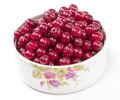 Bowl with ripe cherries. Isolated on a white background. photo