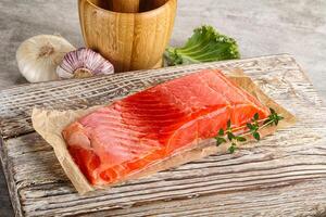 Raw salmon fillet over board photo