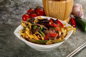 Asian wok with noodle, vegetables and beef photo