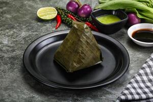 Asian cuisine - rice with filling in banana leaf photo