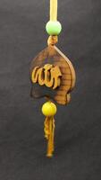 Wooden key chain with Arabic writing isolated photo