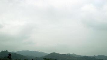 View of hills covered in mist from a field photo