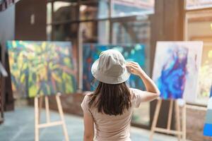 Young female tourist looking gallery exhibition. Art, Painting, photography, Inspiration and museum concept photo