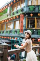 woman traveler visiting in Taiwan, Tourist with hat sightseeing in Jiufen Old Street village with Tea House background. landmark and popular attractions near Taipei city . Travel and Vacation concept photo